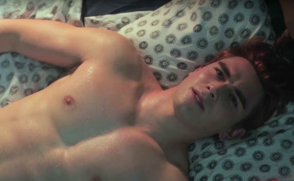 KJ Apa as Archie Andrews, shirtless in bed