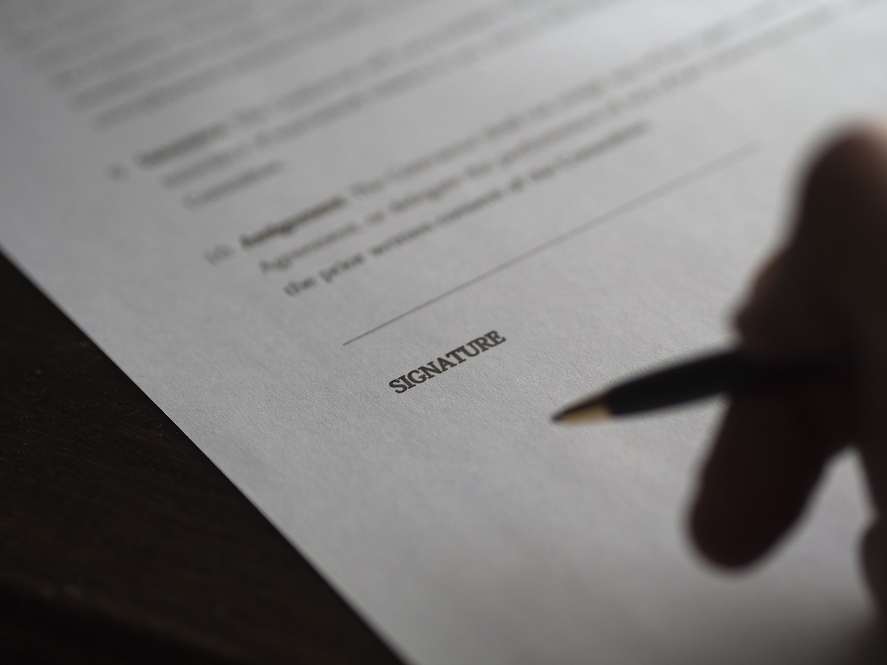 Person hesitating over signature line of contract
