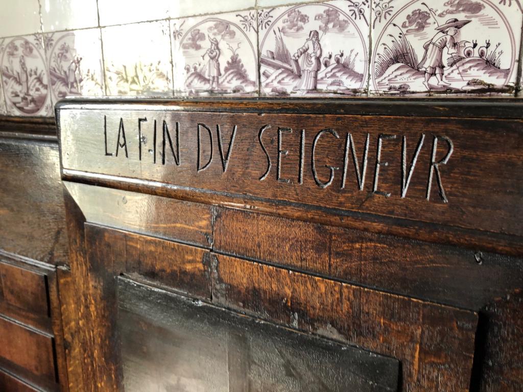 Inscription incised in wood, reading "la fin du seigneur."