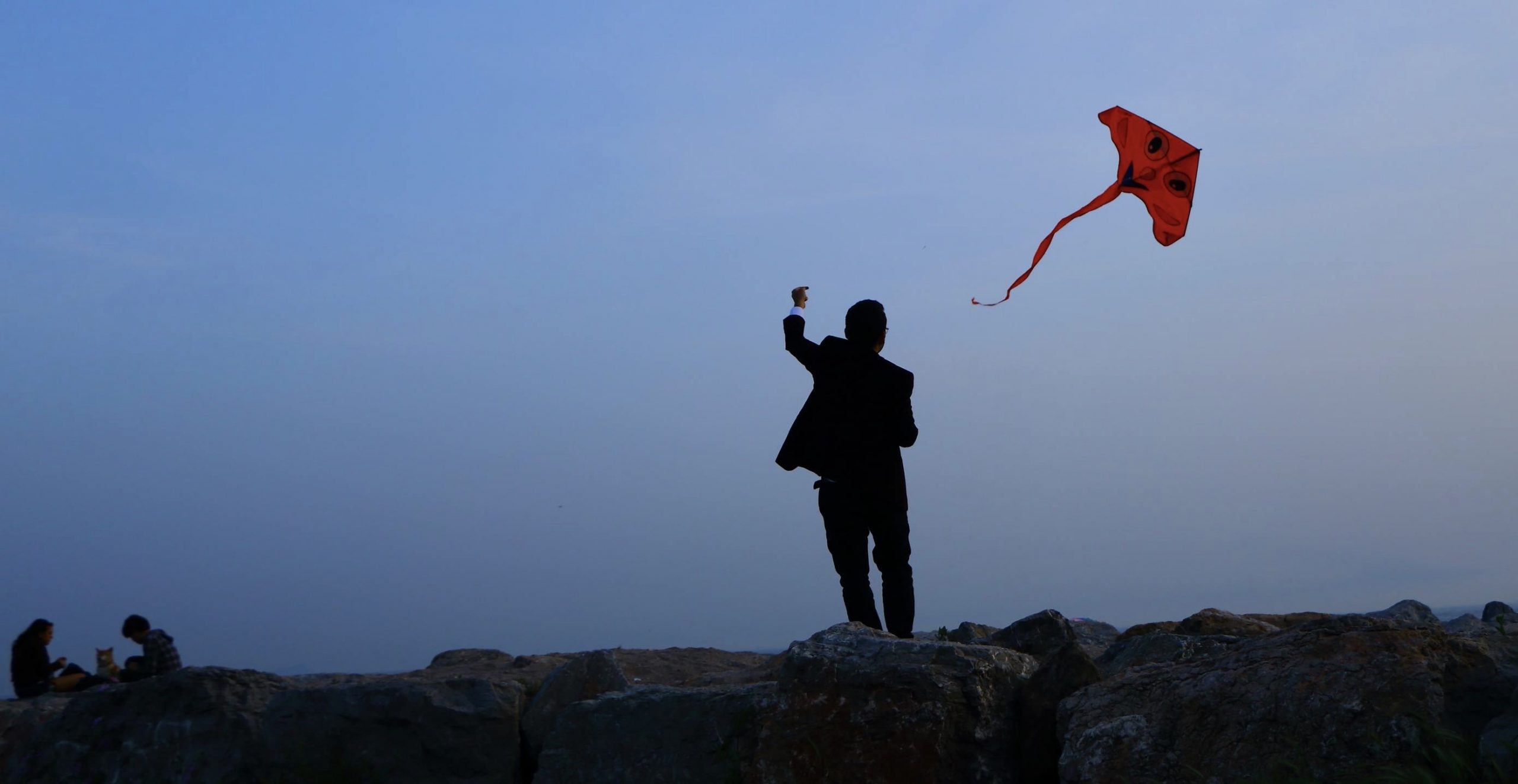 man flying a red kite