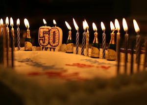 Cake with a candle reading "50"