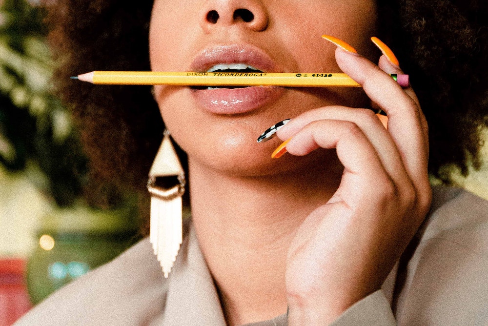 Black woman holding pencil in her mouth