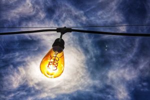 Light bulb against cloudy sky