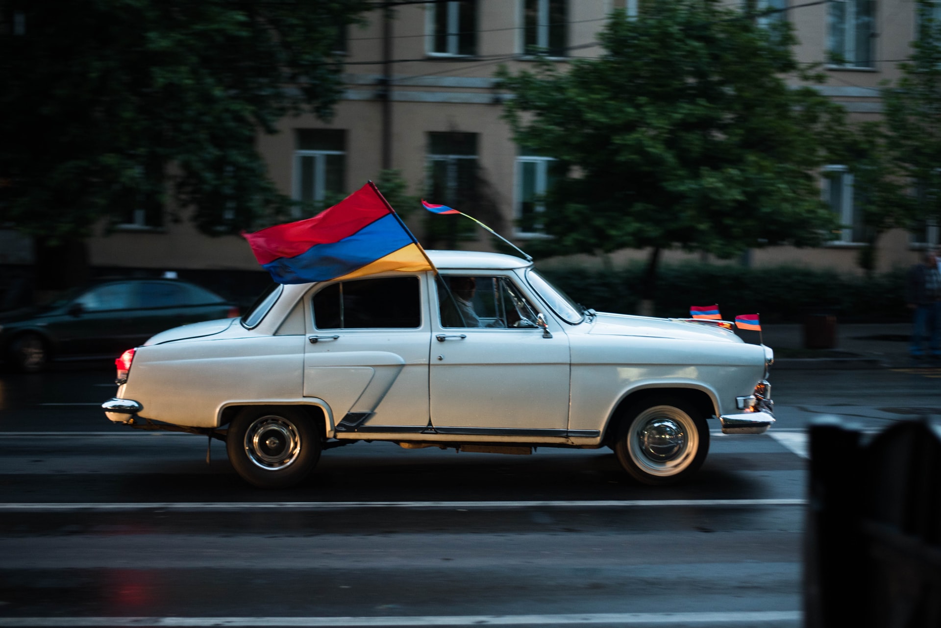 Car flying Armenian flag (red, blue, and gold stripes)