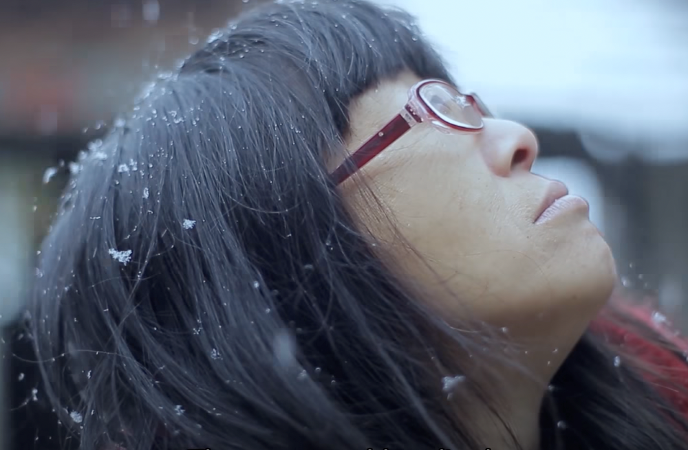 Woman looking up into the snow