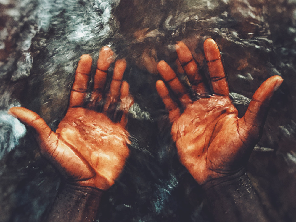 A man holds his hands underwater