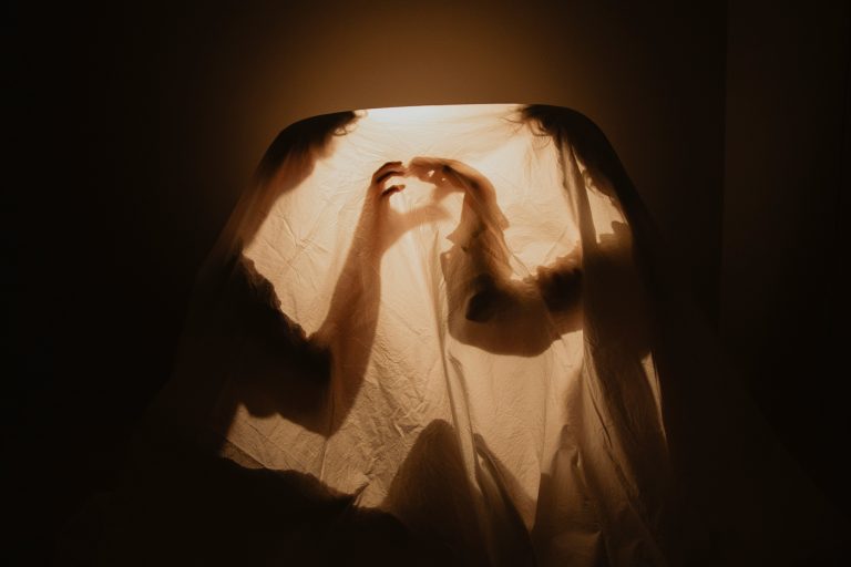 shadows of two people making a heart with their hands