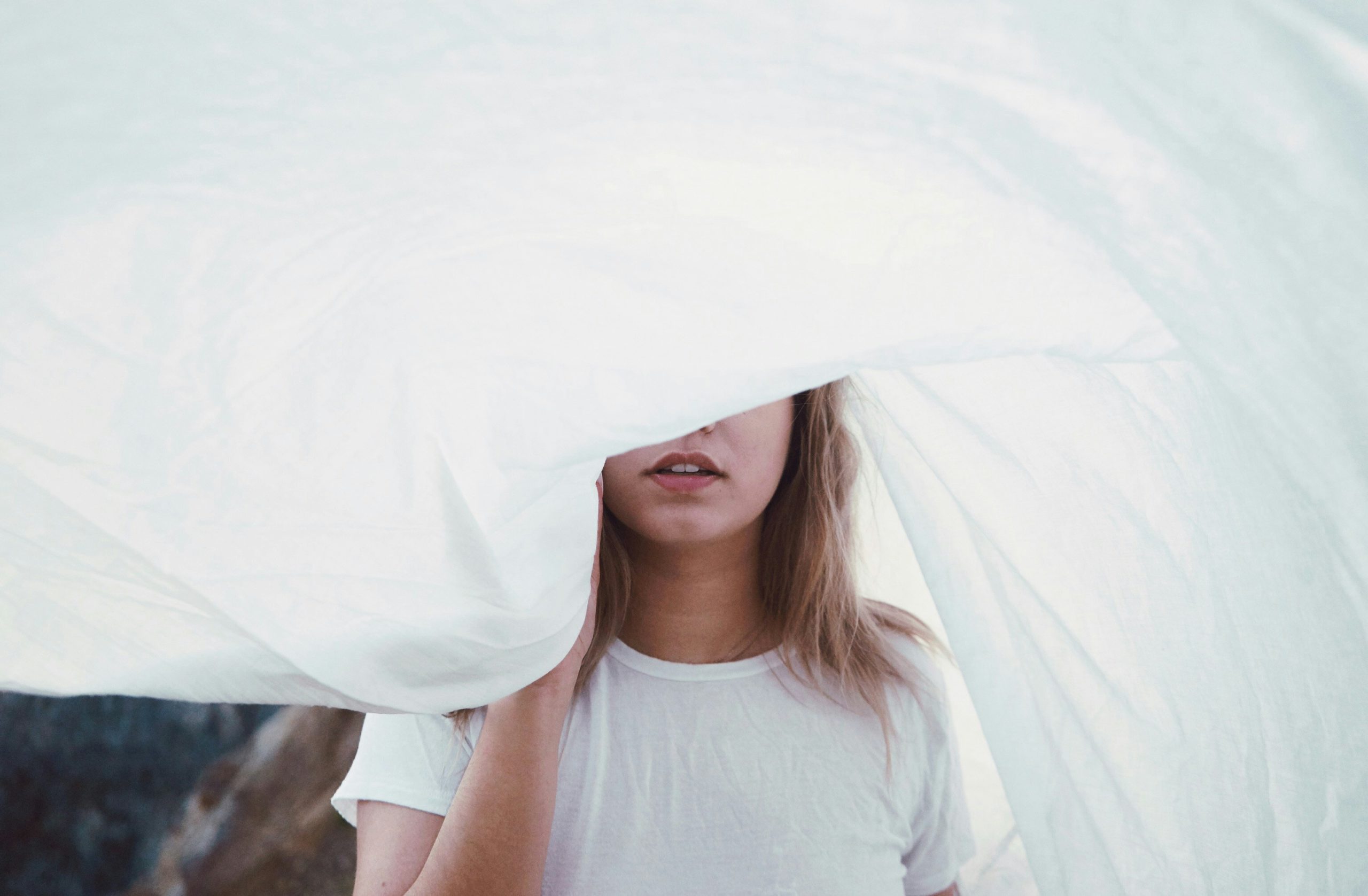 Woman with a white sheet covering her eyes