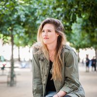 author, sarah hagaman, looking to the left of the camera, with trees in the background